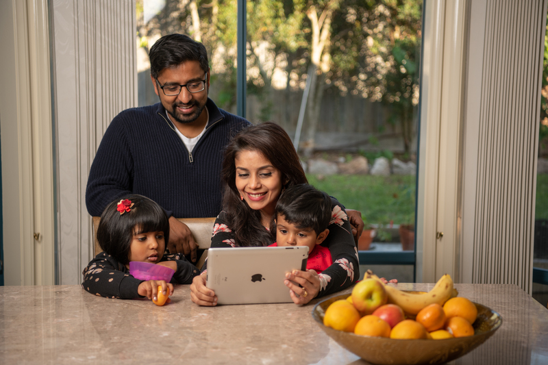 A family sitting together inside looking at an ipad
