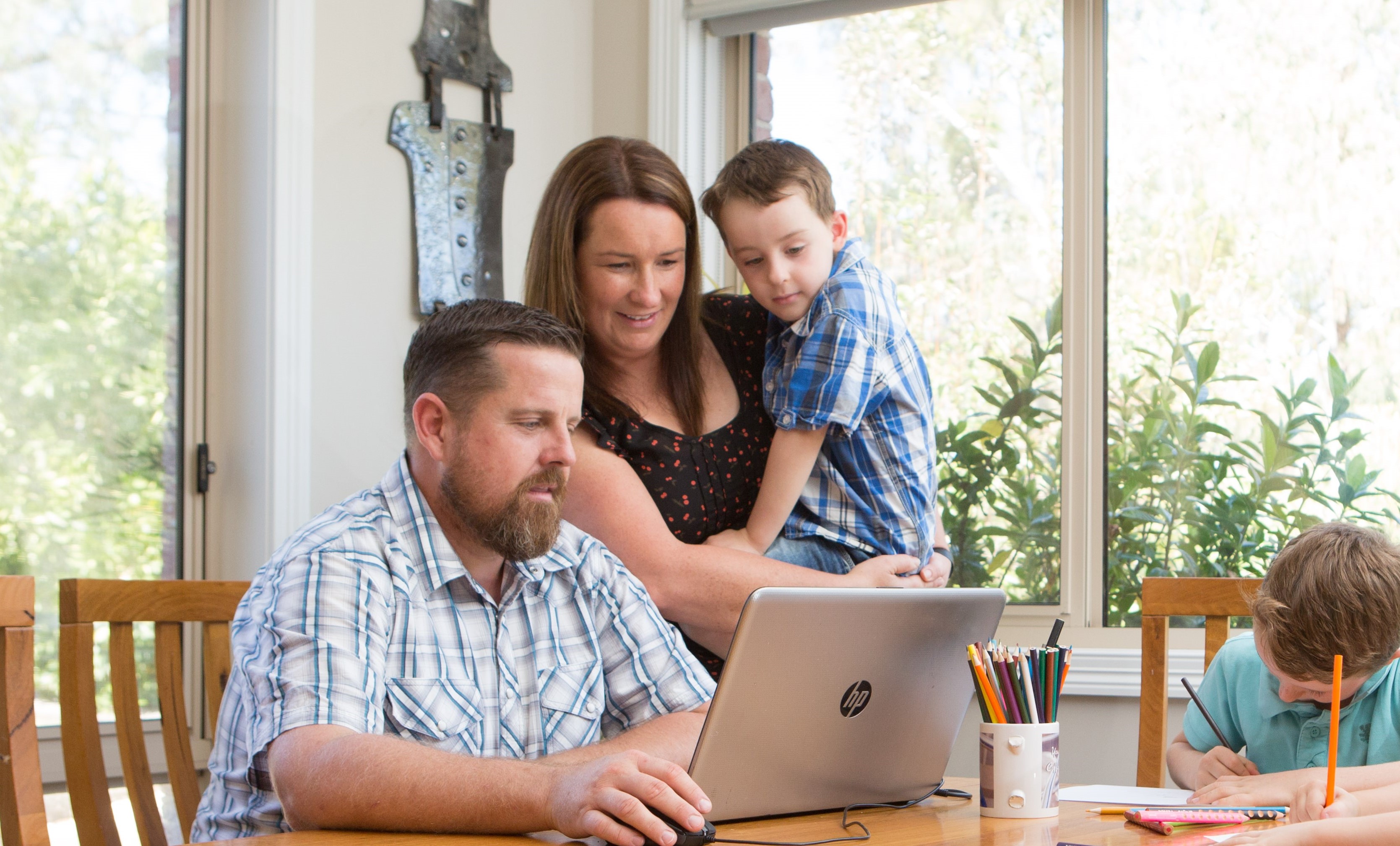 A family looking at a laptop on a living room table