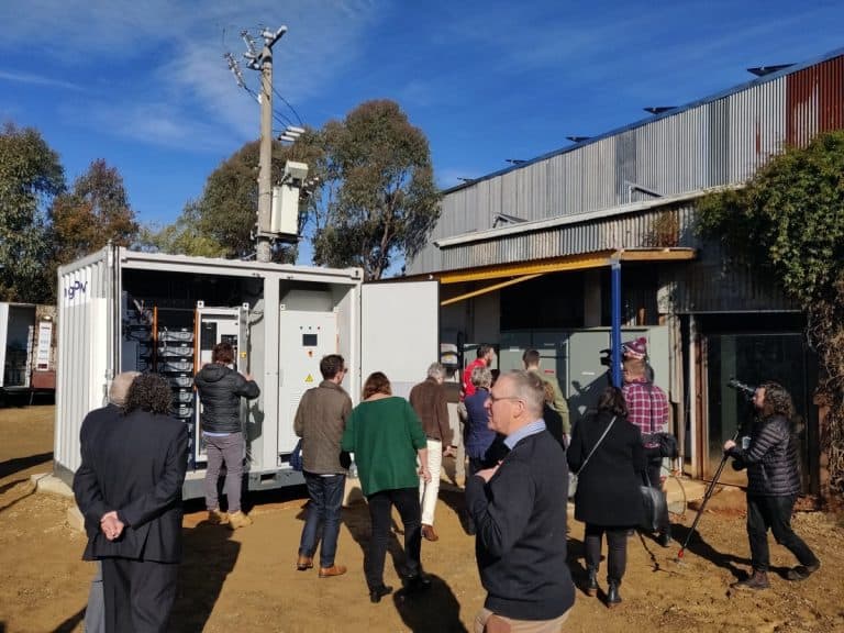 A group of people standing outside near a community battery