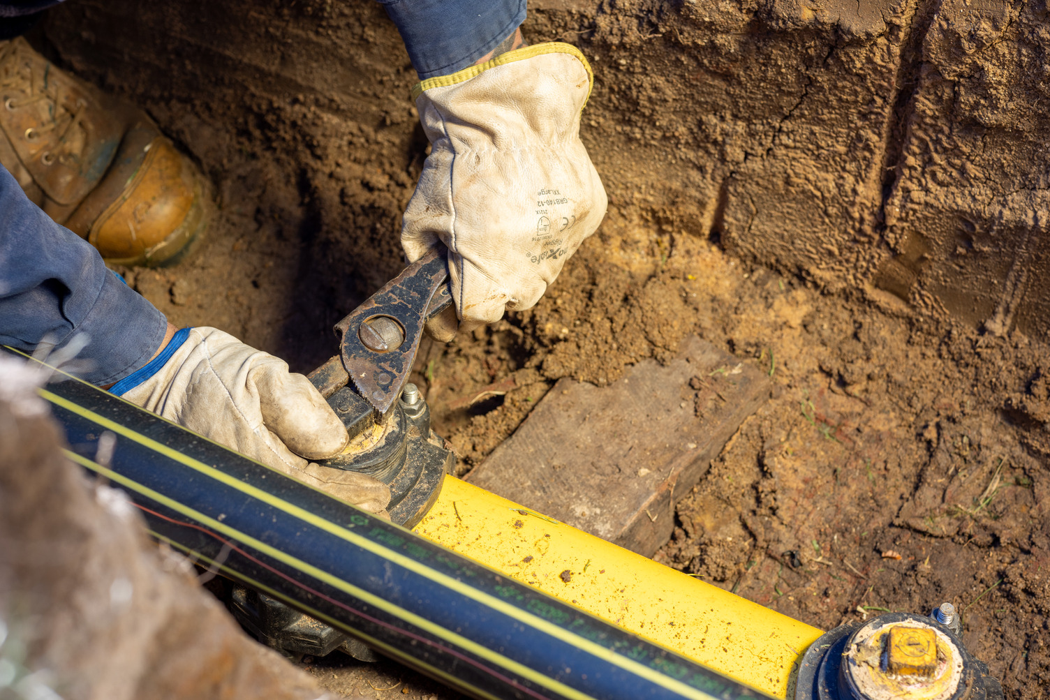A pair of hands working on a gas pipeline