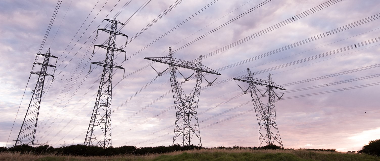 Four powerlines in a row in an open field