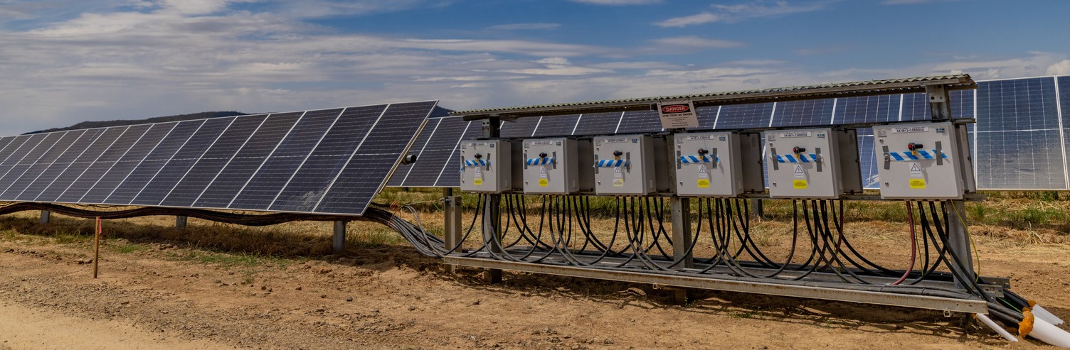 A row of solar panels next to solar panel equipment