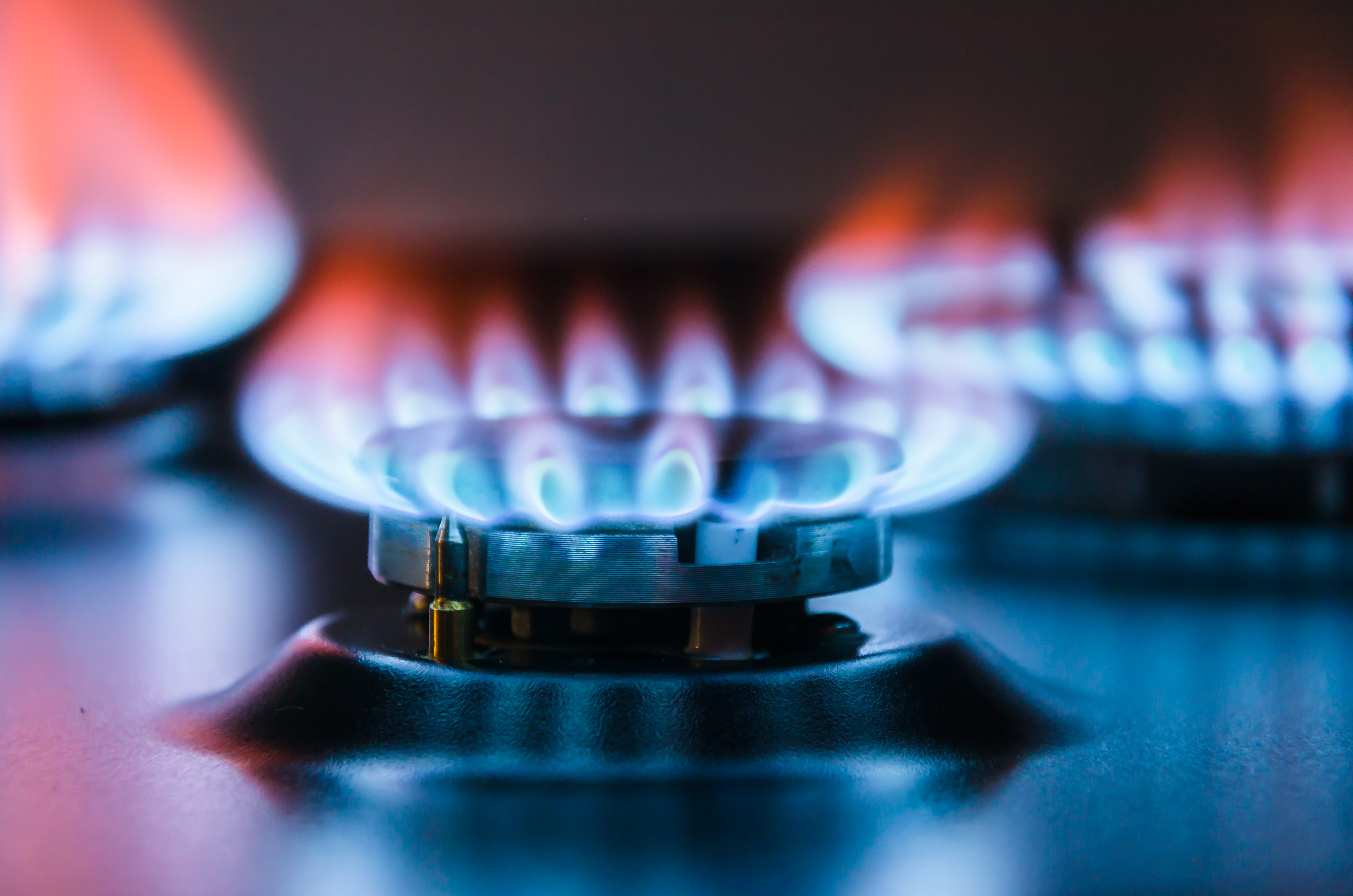 Three lit stove top gas burners